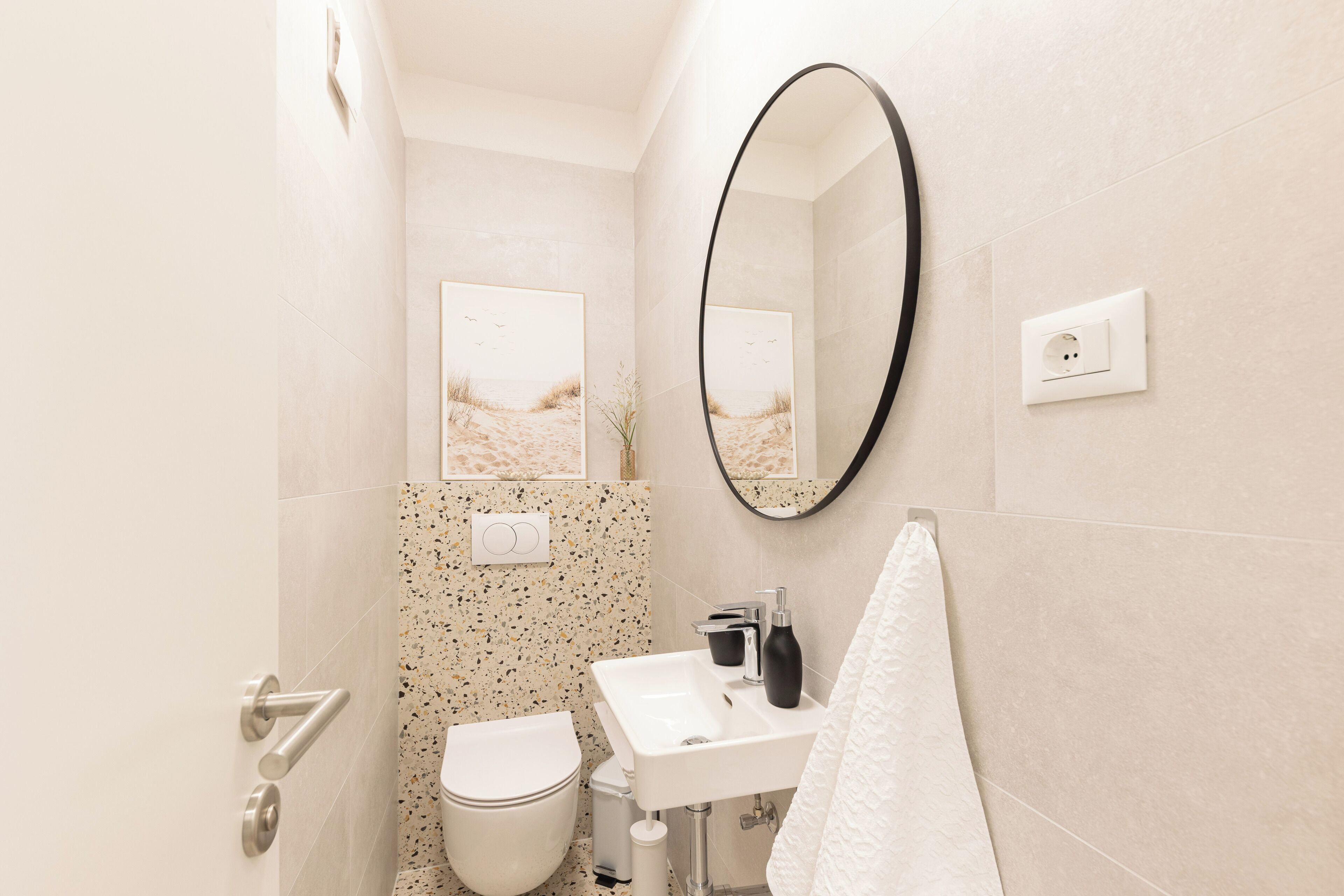 Un baño con inodoro, lavamanos y espejo.