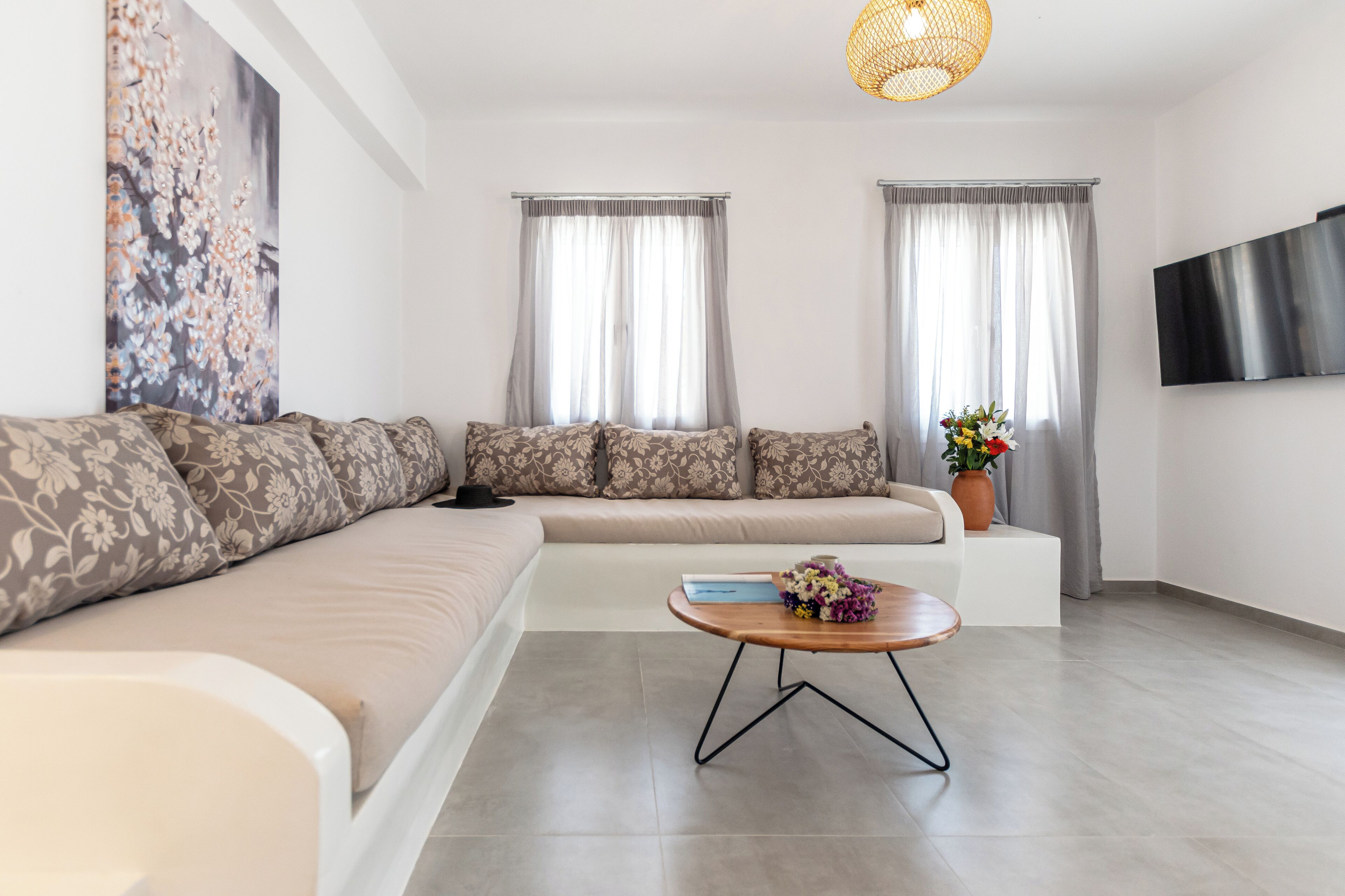 Un salon moderne avec un canapé, une table basse et un téléviseur.