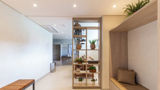 A modern interior with a wooden bench, a built-in shelf with plants, and a seating area with cushions. - 360 Ambience Vila Mariana (São Paulo)