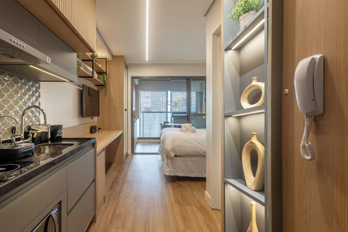 Une chambre d’hôtel moderne équipée d’une cuisine, d’un lit avec vue et d’un téléphone mural.