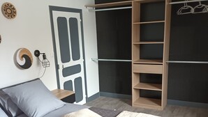 A bedroom with a bed, a wardrobe, and a door.