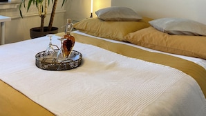 A hotel room with a bed, a painting, a potted plant, and a tray with a bottle and glasses. - Hearty vacation apartment with a warm ambience in a private location (Delmenhorst)