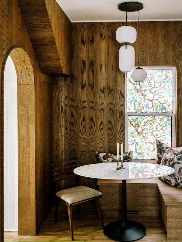 Una habitación acogedora con paredes de madera, una mesa redonda con una vela y un banco.