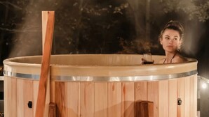 Una sauna de madera con un banco y un vaso de bebida.