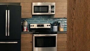 Una cocina moderna con tragaluces, electrodomésticos de acero inoxidable y armarios de madera.