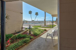 A covered outdoor area with a pool, palm trees, and a garden. - Directly on the Gulf - Unit  6 - 1 Bedroom - Ground Floor - Sleeps 4 (Venice)