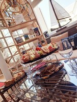 Una mesa de comedor con diferentes alimentos y una copa de vino.