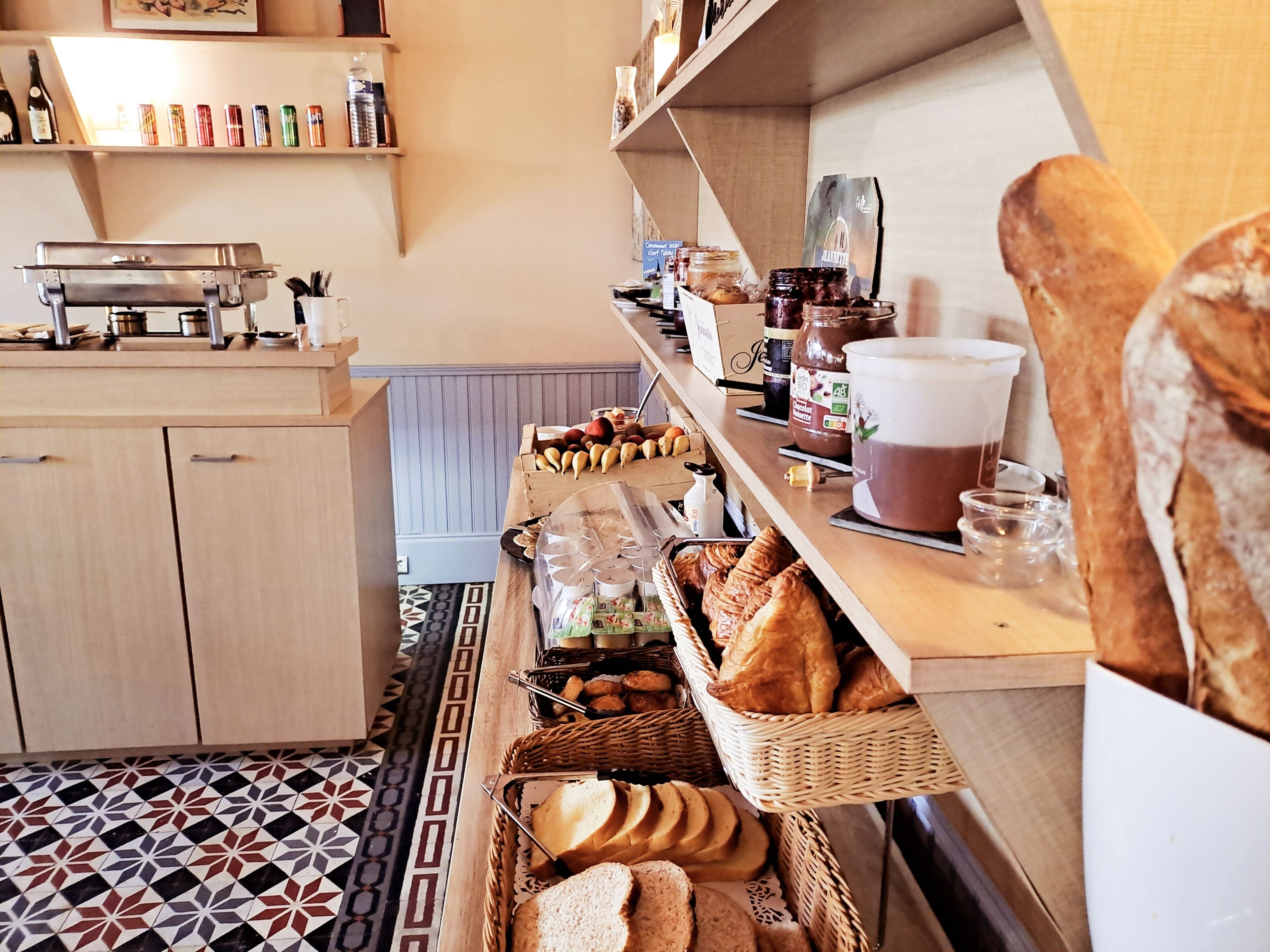 A kitchen with wooden cabinets, a countertop with various food items, and a patterned floor.