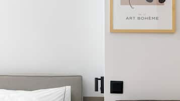 Una camera d'albergo con un letto, un'opera d'arte incorniciata appesa al muro e un divano scuro.