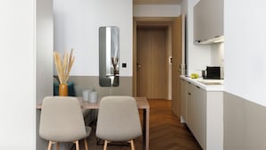 A modern kitchen with white cabinets, a wooden countertop, and a built-in stove. - ERMASS Athens (Athens)