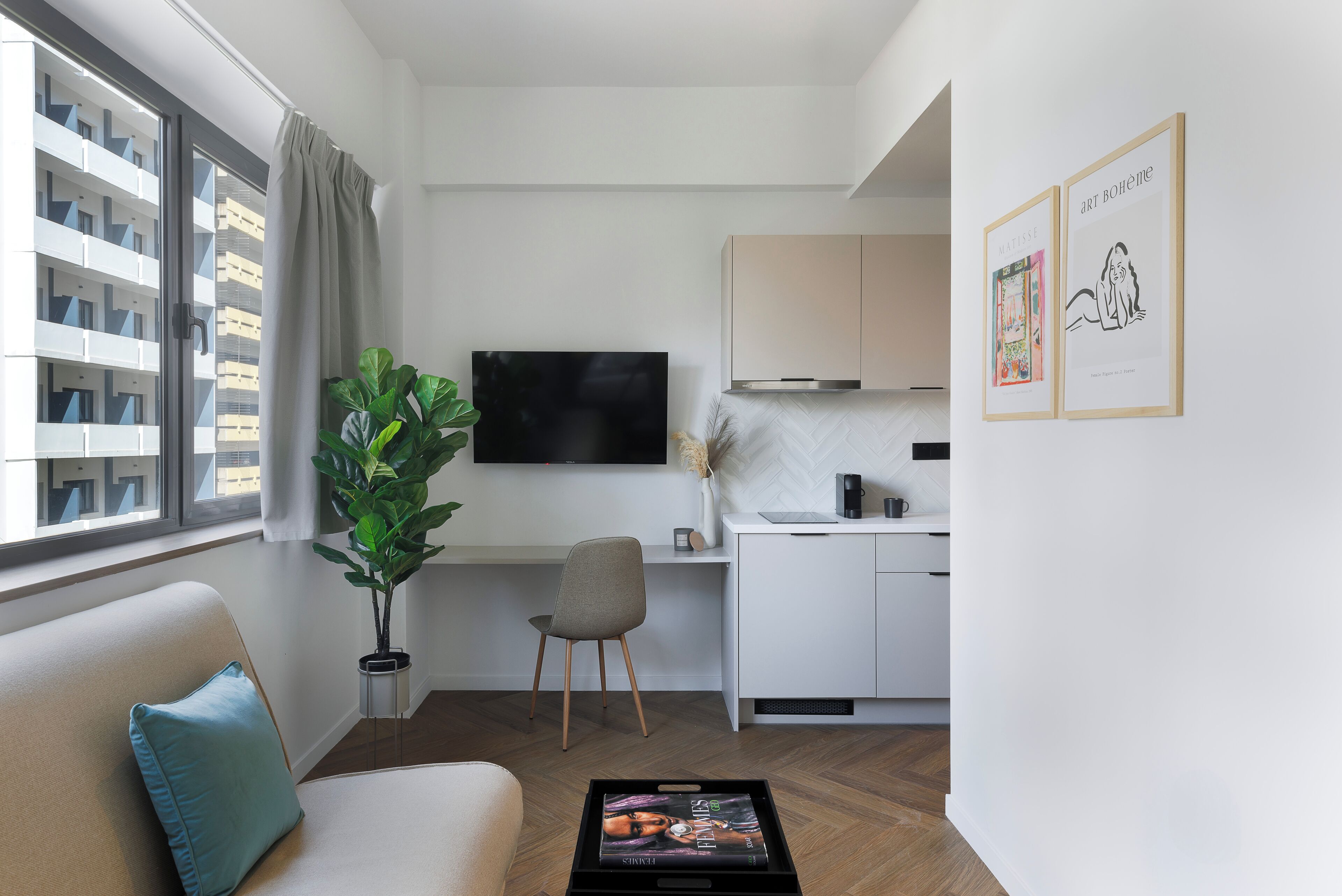 A modern living room with a sofa, a coffee table, a TV, and a dining area with a table and chairs.