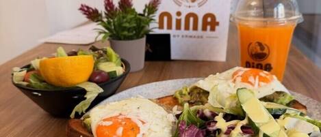A meal with a salad, a sandwich, and a drink on a table.