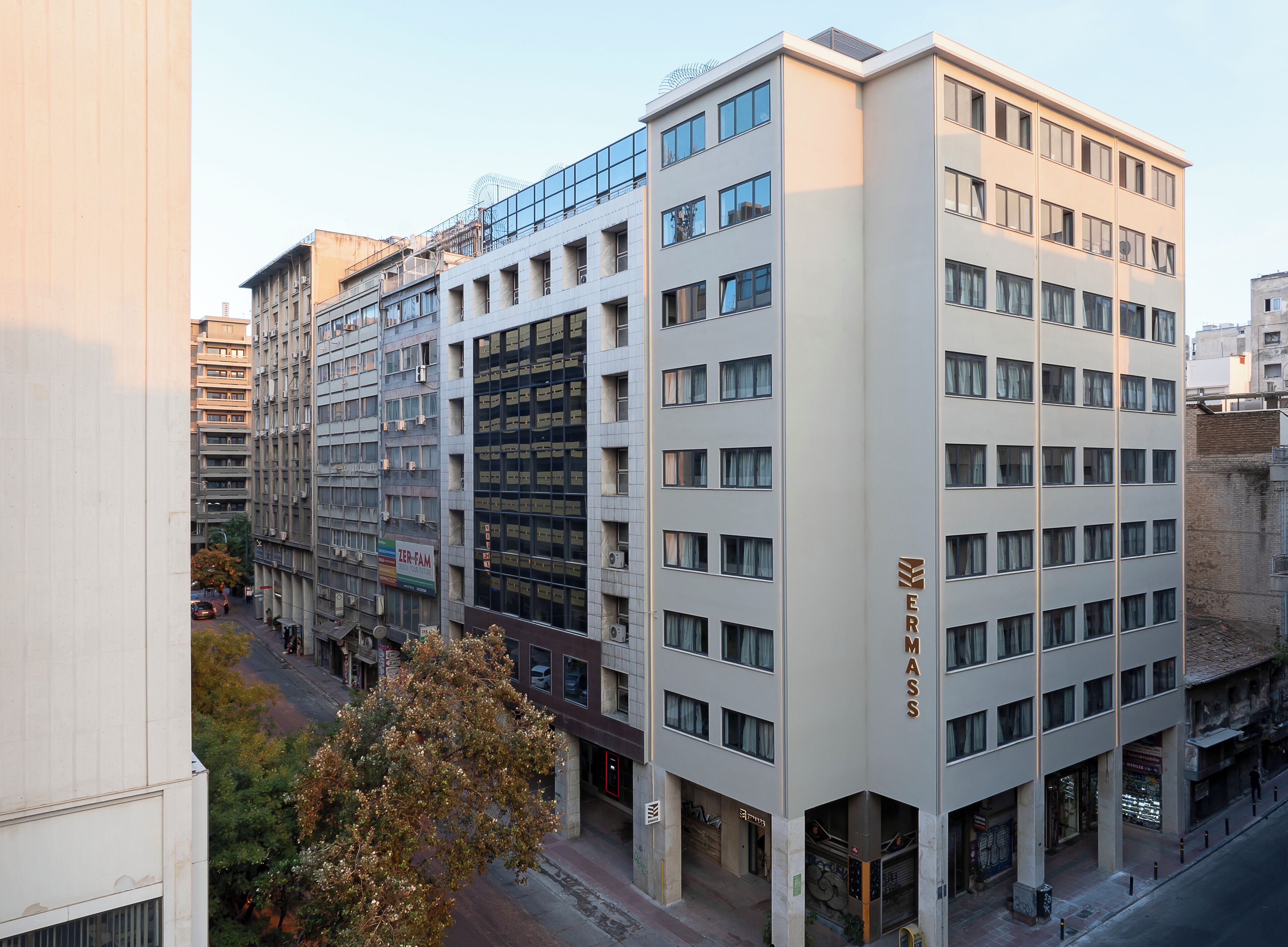 A multi-story hotel with a modern facade, large windows, and a visible entrance with a sign.