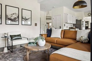 A modern living room with a sofa, coffee table, and artwork on the wall.
