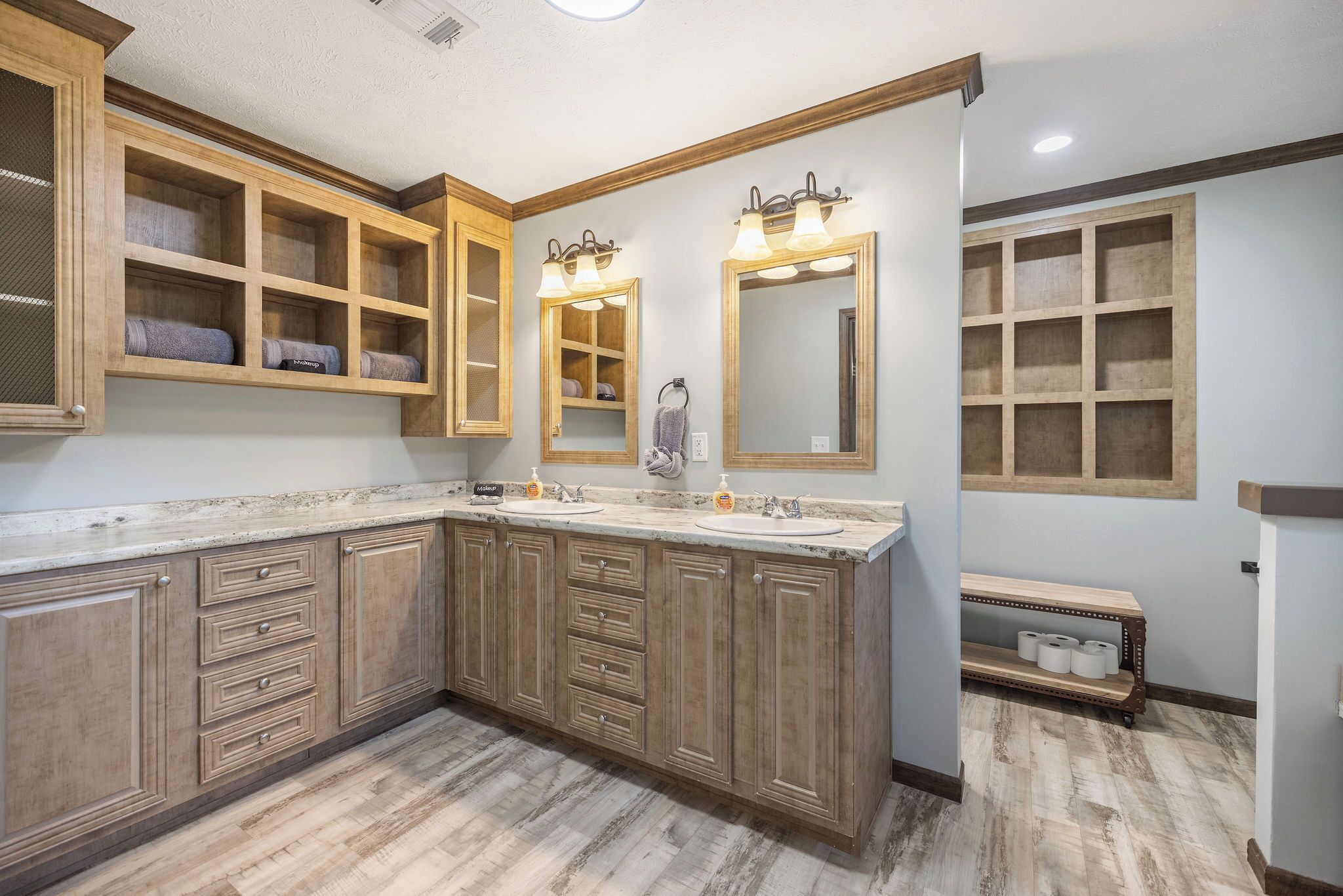 A bathroom with wooden cabinetry, two sinks, and a large mirror.