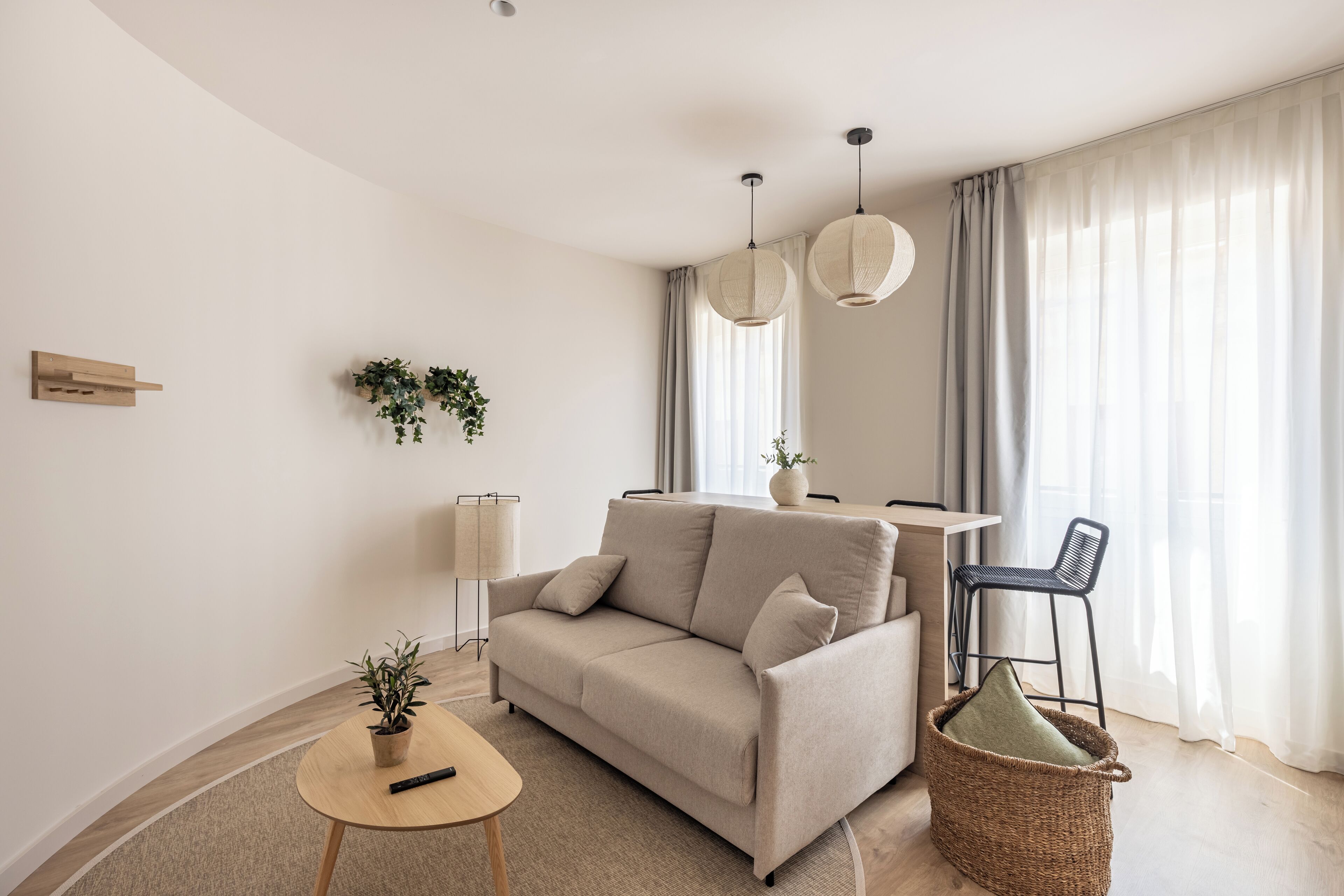 Una sala de estar moderna con un sofá, una mesita, una silla y una cesta.