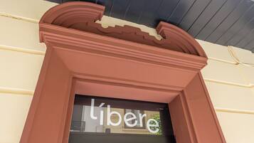 Ein Schaufenster mit einer braunen Fassade und einem schwarzen Fenster, auf dem das Wort "liber" zu sehen ist.