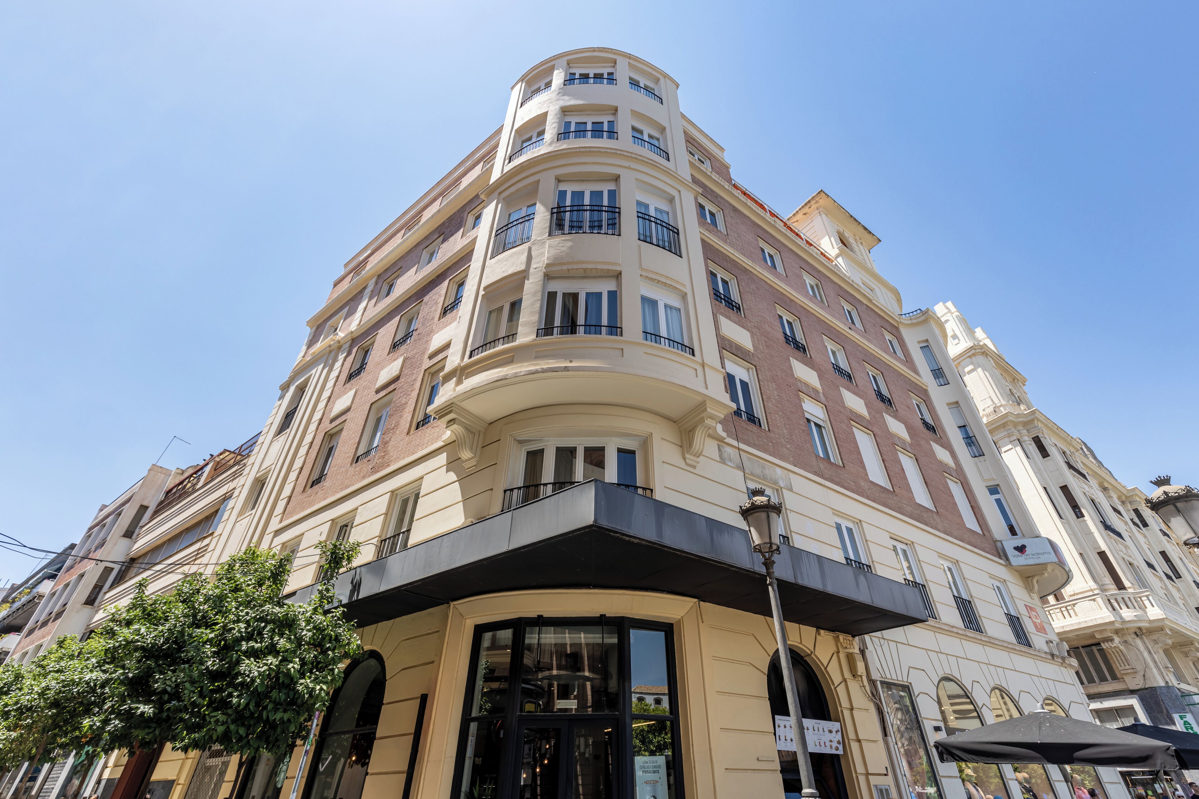 Ein mehrstöckiges Gebäude mit einer geschwungenen Fassade, großen Fenstern und Balkonen.