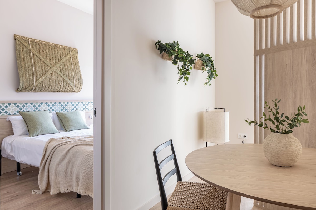 A modern bedroom with a bed, bedside table, and a wall-mounted plant.