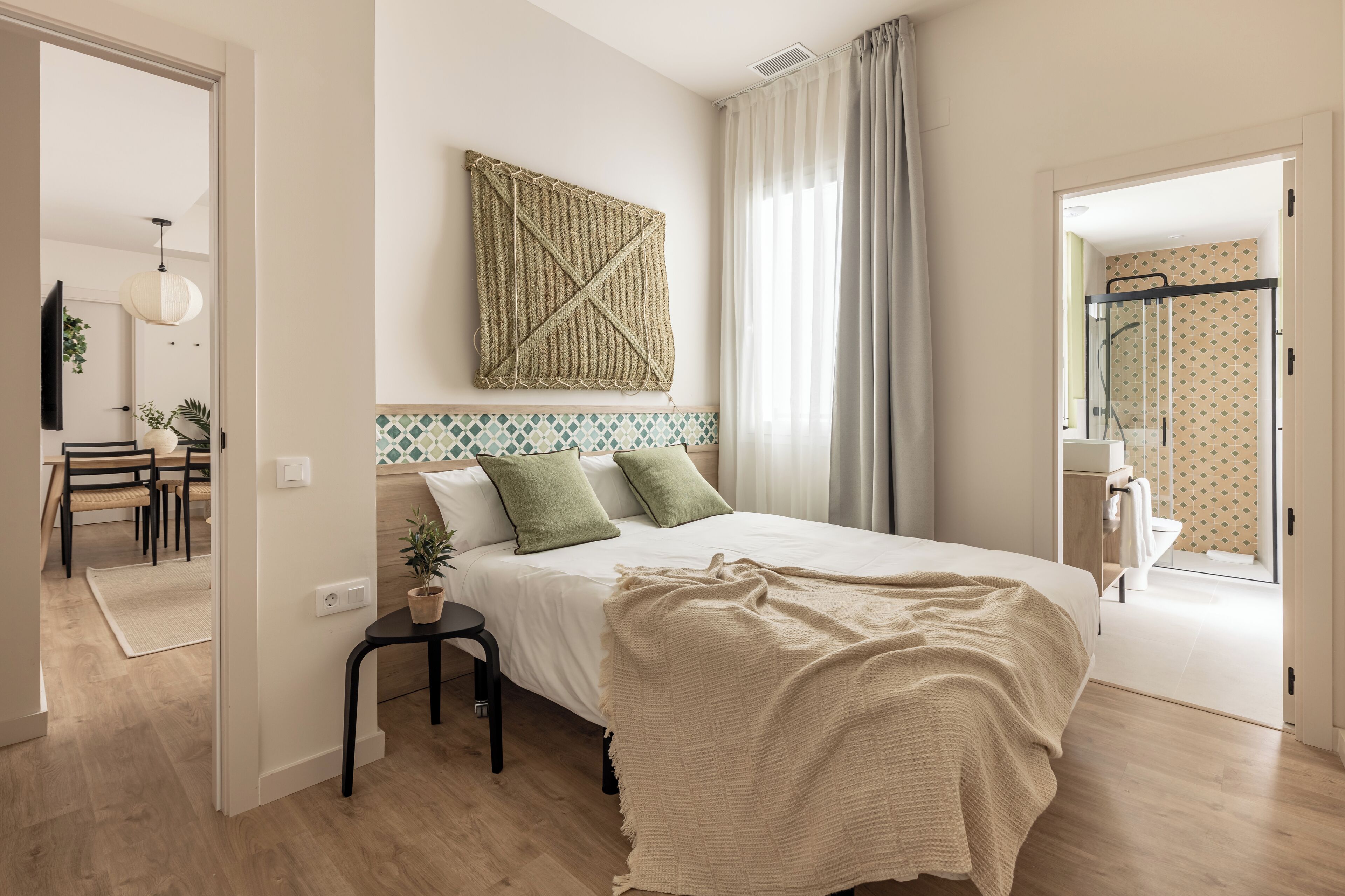 Une chambre à coucher avec un lit, une table de chevet et un miroir.