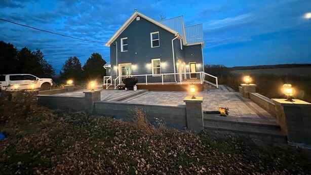 A two-story house with a porch, a garage, and a driveway.