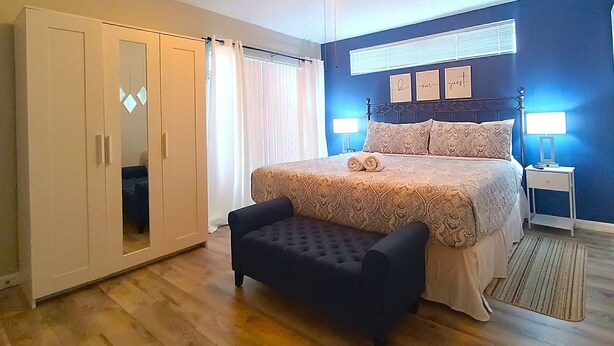 A bedroom with a bed, a chest of drawers, a ceiling fan, and a bedside table with a lamp. - Private Pool • Game Room • Near Disney (Davenport)