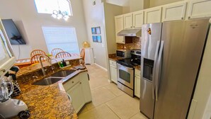 A modern kitchen with granite countertops, stainless steel appliances, and white cabinetry. - Private Pool • Game Room • Near Disney (Davenport)
