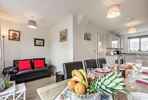 Eine moderne Wohnung mit Essbereich, Küche und Wohnzimmer.