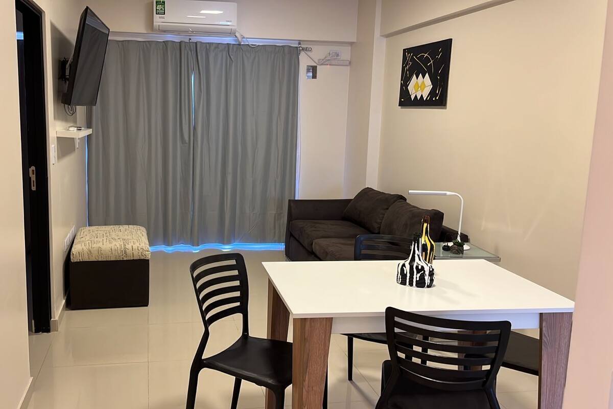 A modern living room with a sofa, a coffee table, and a TV mounted on the wall.