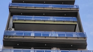 Ein mehrgeschossiges Gebäude mit Balkonen und großen Fenstern.