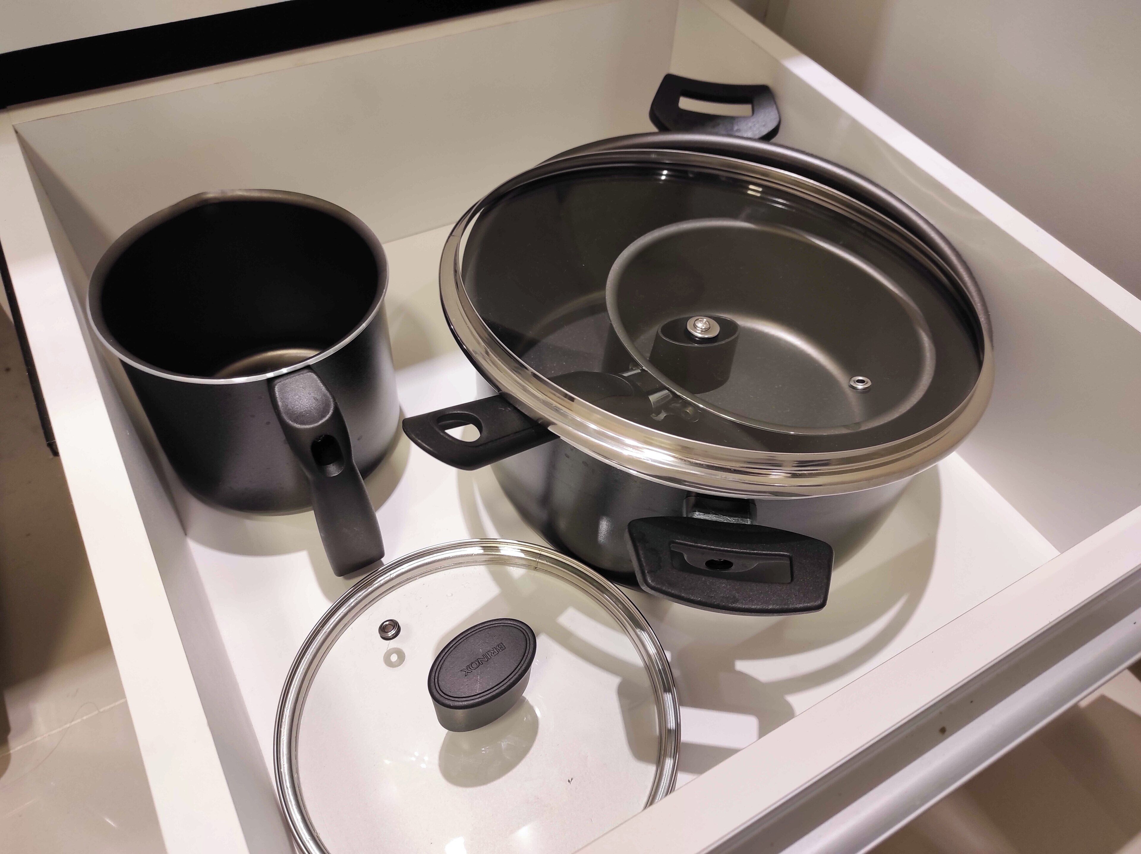 A kitchen with a stove, a pot, and a pan.
