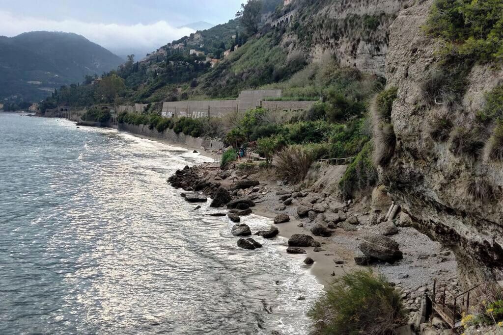 Un paisaje costero con acantilados rocosos, una playa y vista al mar.