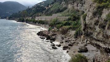 Un paisaje costero con acantilados rocosos, una playa y vista al mar.