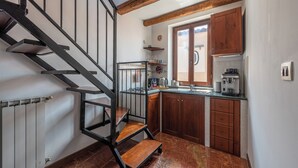 A kitchen with wooden cabinets, a built-in oven, and a coffee machine. - Le terrazze nel cuore della Kalsa by Wonderful Italy (Palermo)