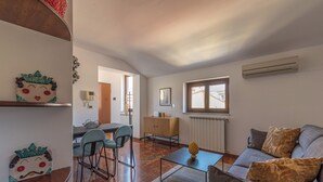 A modern living room with a sofa, coffee table, and a dining area with chairs and a table. - Le terrazze nel cuore della Kalsa by Wonderful Italy (Palermo)