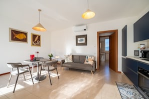 Appartamento, patio, vista giardino | Area soggiorno | TV 35 pollici con canali digitali
