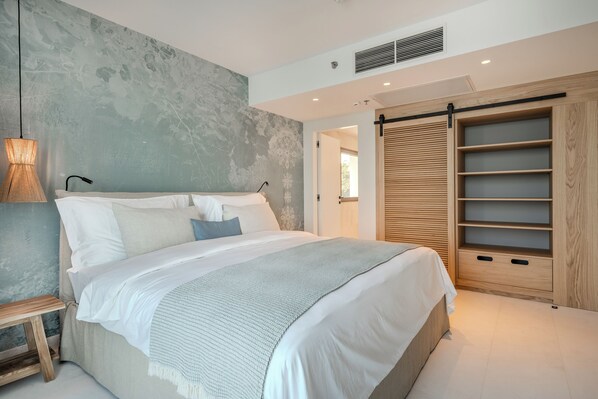 Une chambre moderne avec un grand lit, une armoire en bois et un mur à texture.