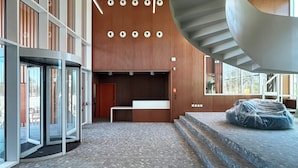 A spacious lobby with a curved staircase, large windows, and a modern design. -  Valencia Tower (Burjasot)