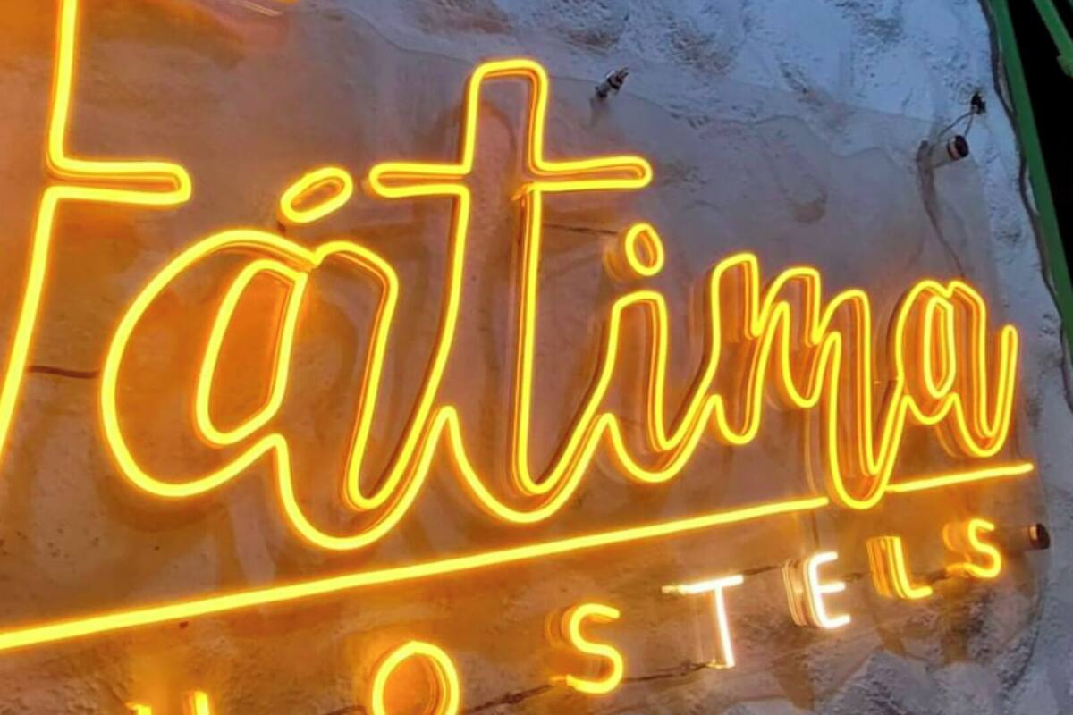 Une enseigne au néon avec l’inscription « Tätima Hostels ».