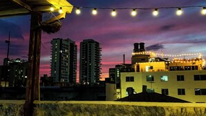 A cityscape at dusk with illuminated buildings and string lights. - Fatima Hostel Santa Marta (Santa Marta)