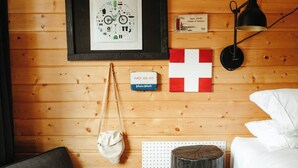 Un muro di legno con un quadro incorniciato, una piccola insegna, una bandiera, una lampada e una borsa.