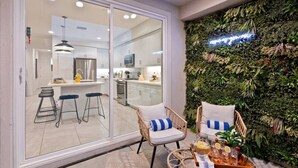 A modern kitchen with a glass door leading to a dining area. - Luxe Lakefront Dream Villa: Heated Saltwater Pool (Indio)