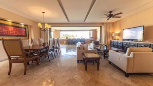 A spacious living area with a dining table, sofas, a TV, and a ceiling fan. - 8 rounds of golf included at Zoetry Casa del Mar Los Cabos - 2 Bedroom unit  (San José del Cabo)