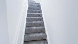 Eine Treppe mit Handlauf und Deckenleuchte.