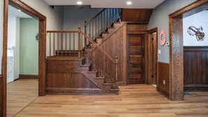 Una escalera de madera con barandilla, que conduce a un rellano con una puerta.
