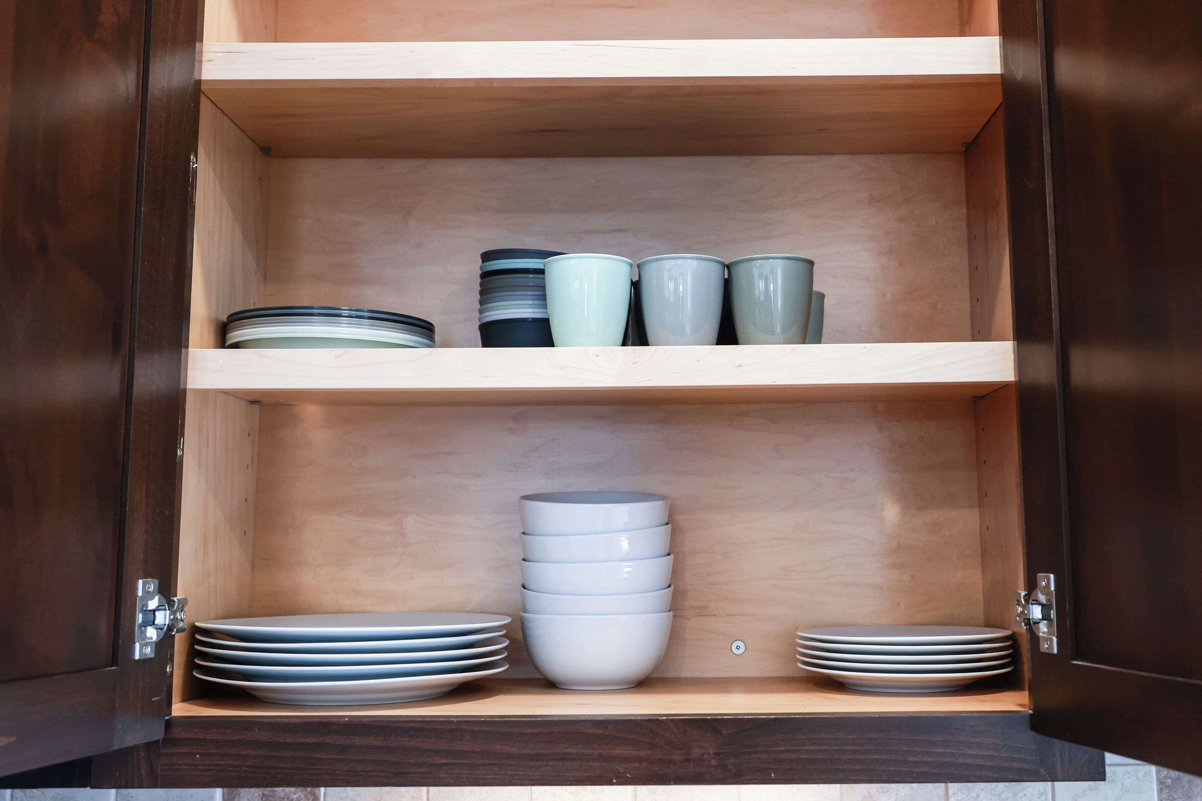 Un mueble de madera con estantes que contienen platos y cuencos.
