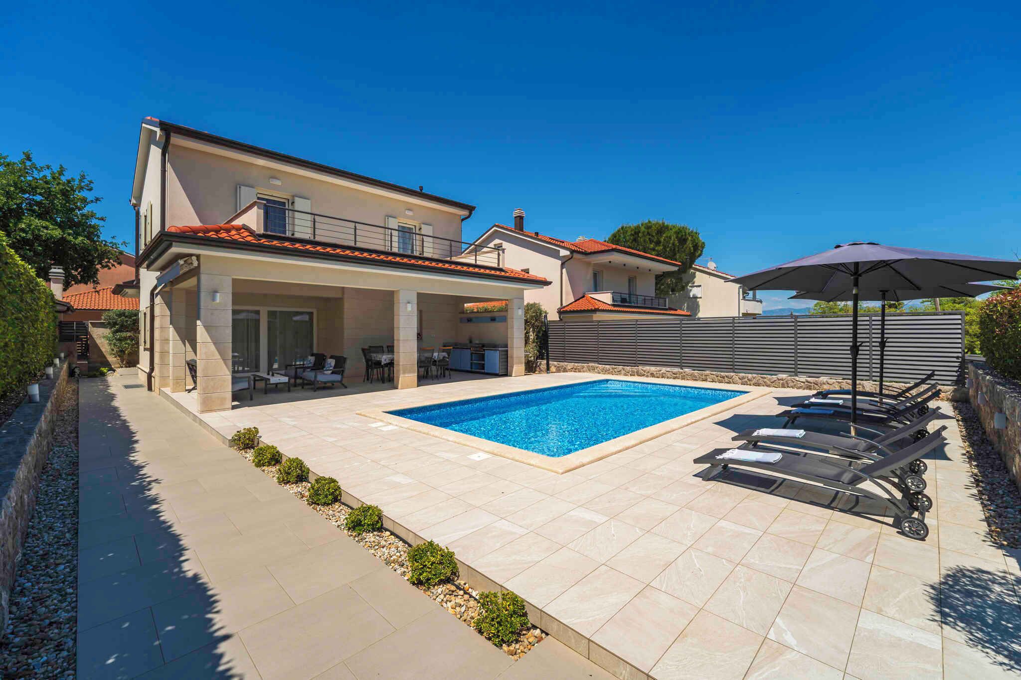 Une maison moderne dotée d’une piscine, d’un espace salon extérieur et d’un patio couvert.