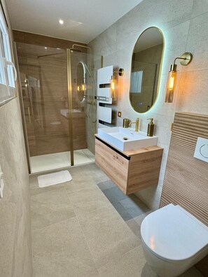 Een douche, handdoeken, zeep, toiletpapier