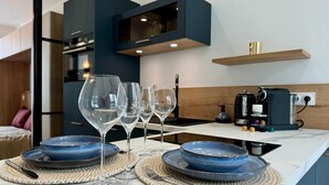 A modern kitchen with a marble countertop, wine glasses, and blue plates set for a meal. - Cocoon 5 minutes from town center and station (Amiens)
