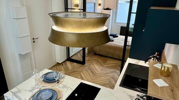 Een moderne keuken met een centraal eiland, inbouwapparatuur en uitzicht op de woonkamer.